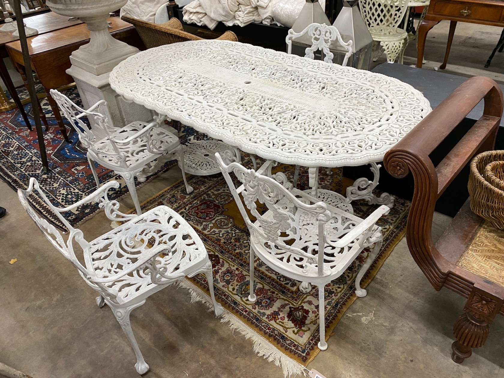 A Victorian style painted cast aluminium garden table, length 180cm, width 90cm, height 72cm and four matching elbow chairs